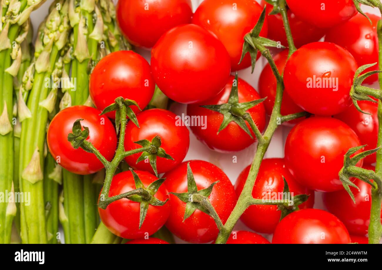 Chiodatura di pomodori ciliegini e asparagi verdi Foto Stock