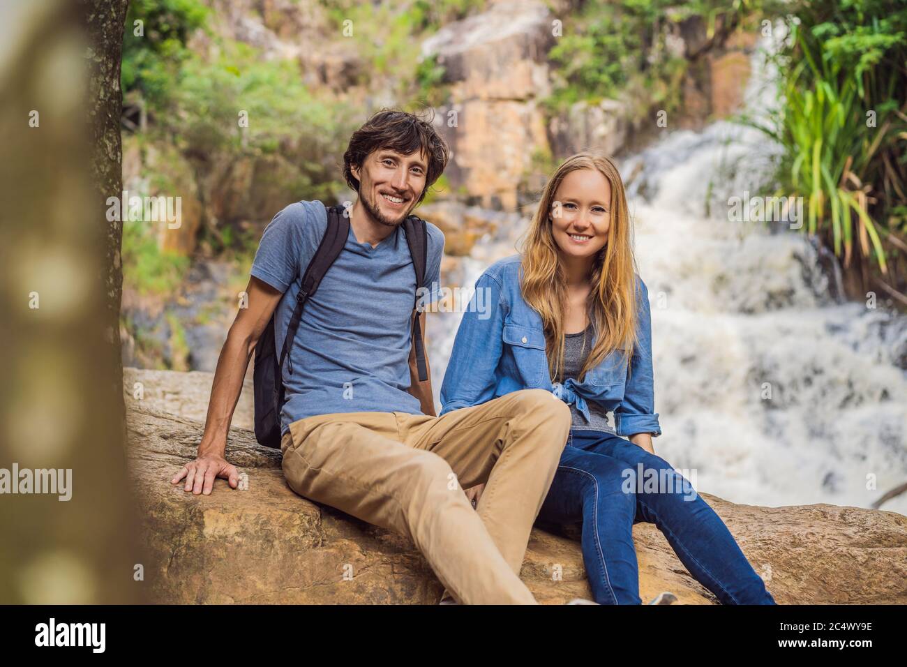 Coppia di turisti con uno zaino sullo sfondo di una cascata Foto Stock