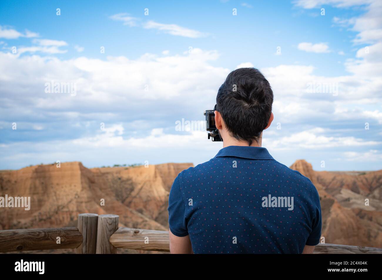 giovane cineasta che filma paesaggi naturali in canyon con un grande fiume e paludi Foto Stock