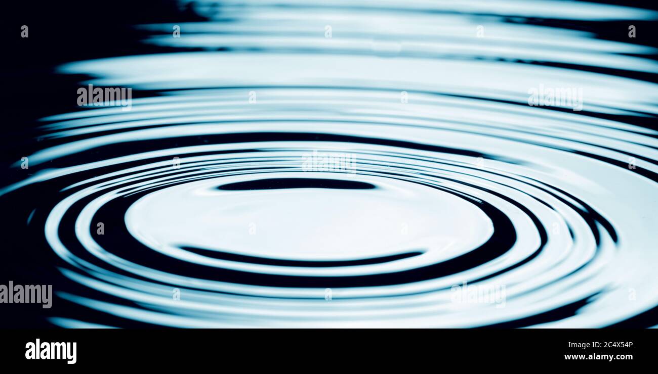 Goccia d'acqua che cade in acqua facendo un perfetto cerchio concentrico. Foto Stock