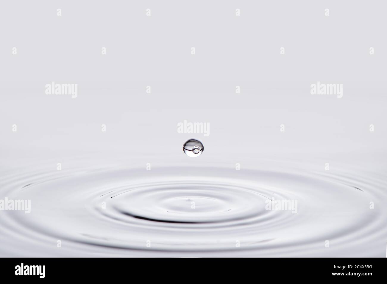 Primo piano acqua bianca goccia che cade giù. Foto Stock