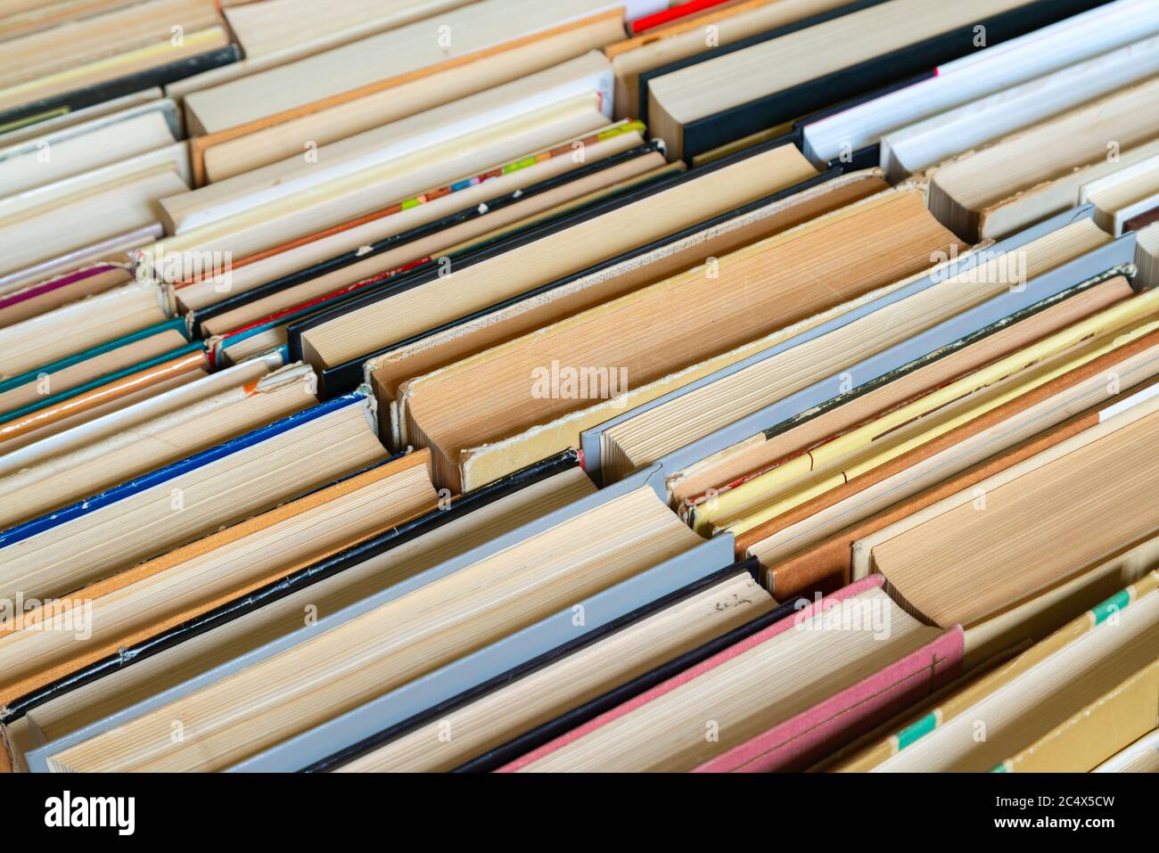 Sfondo del libro d'epoca. Libri vecchi e usati di hardback impilati uno accanto all'altro. Concetto di istruzione e di studio. Nessuno Foto Stock