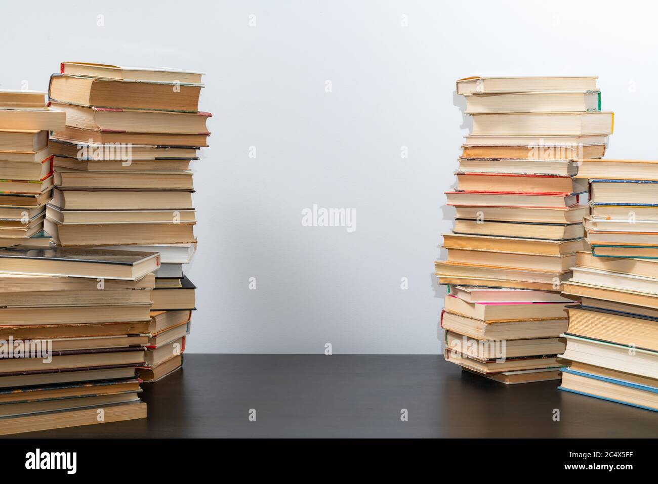 Grande pila di libri sul tavolo. Studiare prima dell'esame. Pila di libri d'epoca. Concetto di istruzione e di studio Foto Stock