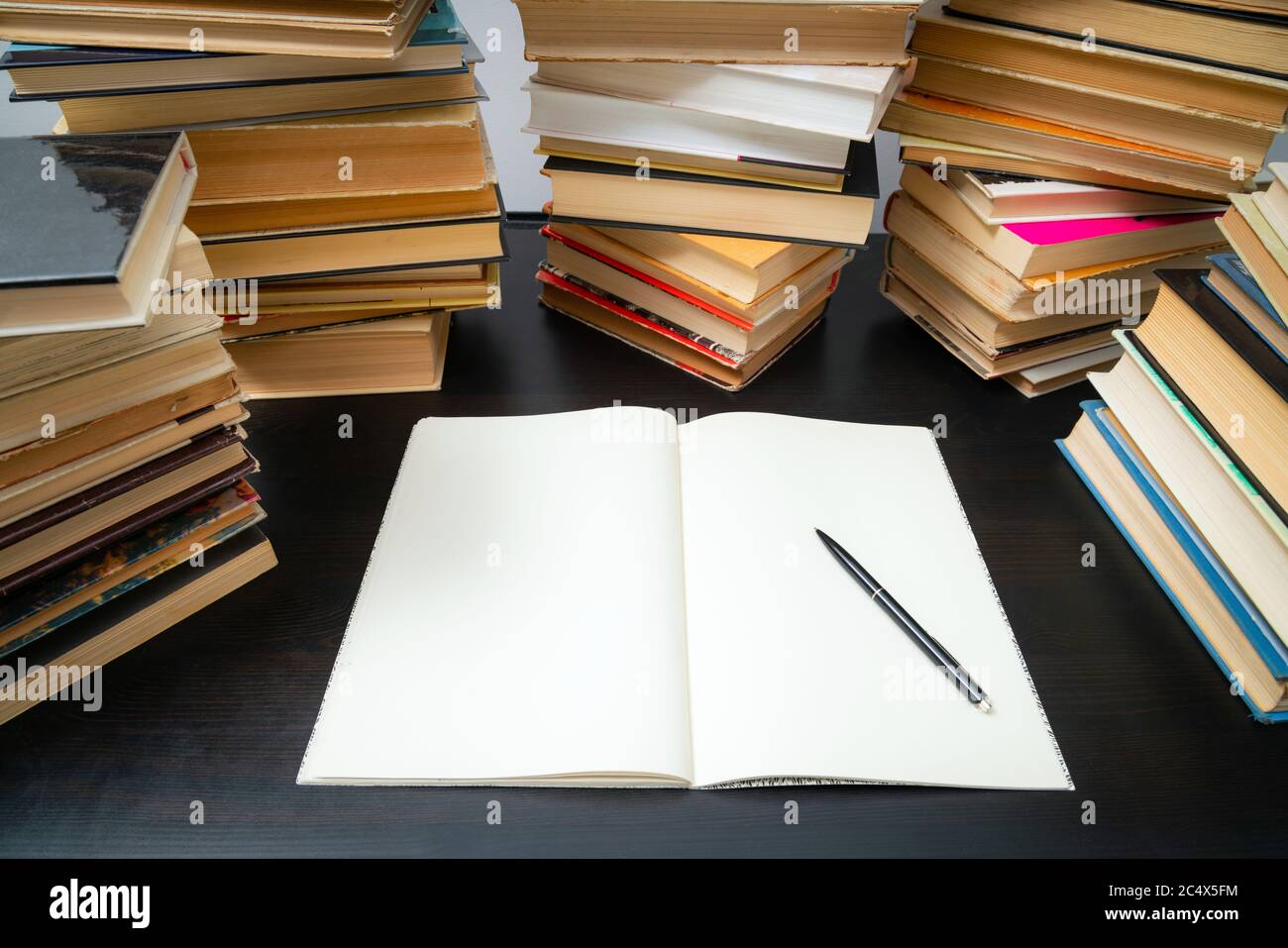 Grande pila di libri sul tavolo. Studiare prima dell'esame. Pila di libri d'epoca. Concetto di istruzione e di studio Foto Stock