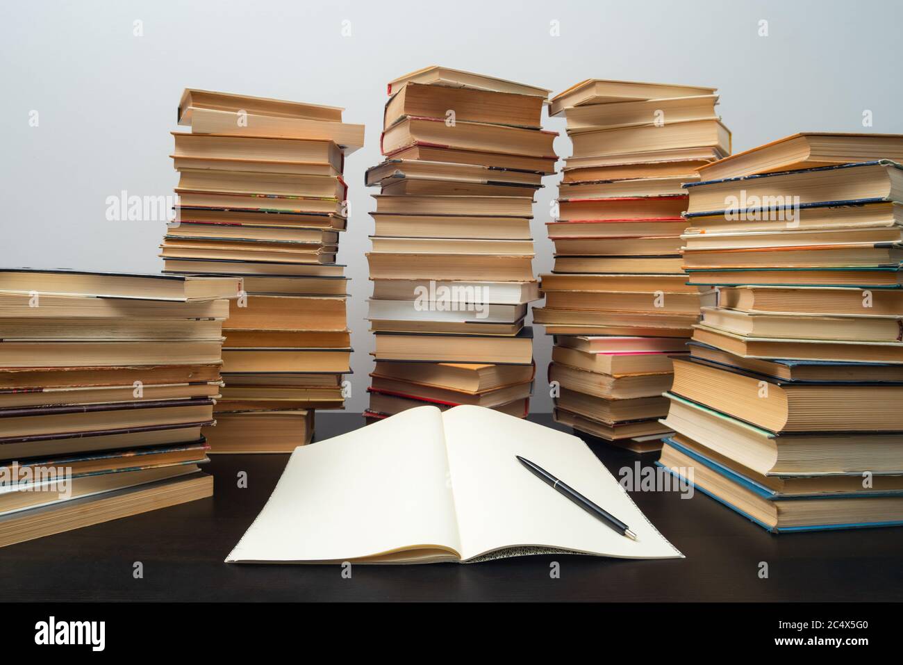 Grande pila di libri sul tavolo. Studiare prima dell'esame. Pila di libri d'epoca. Concetto di istruzione e di studio Foto Stock