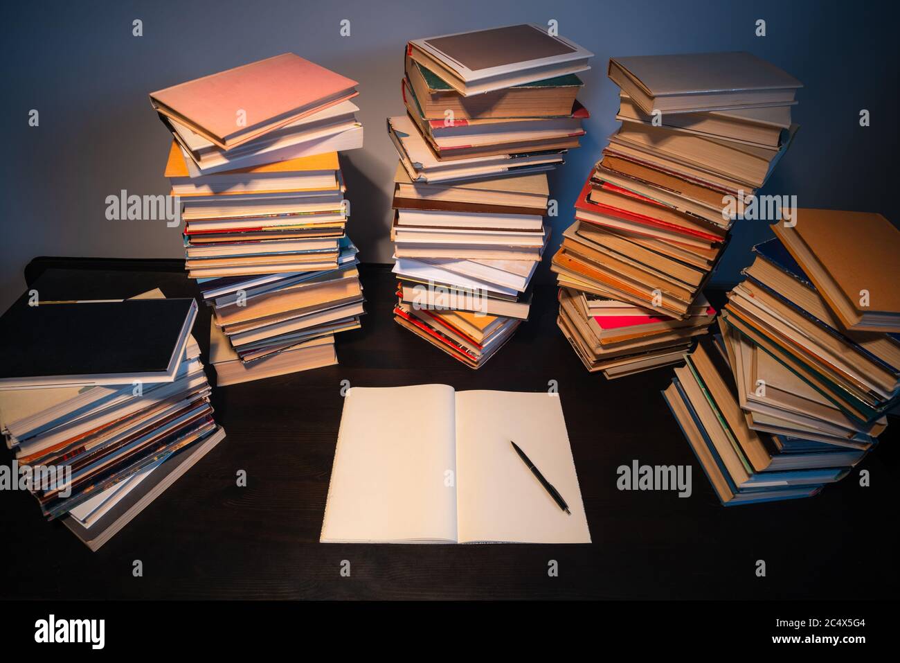 Grande pila di libri sul tavolo. Studiare prima dell'esame. Pila di libri d'epoca. Concetto di istruzione e di studio Foto Stock