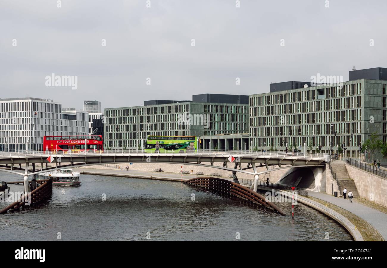 Vista di un tour della città rosso e verde, autobus turistici che attraversano il Ponte del Principe Corona sul fiume Sprea e il moderno Ministero dell'Istruzione. Foto Stock