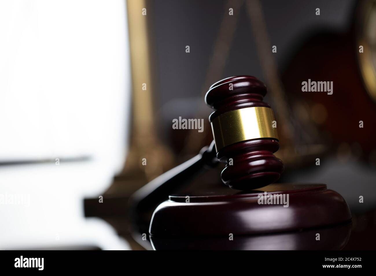 Concetto di legge. Giudica gavel di legno, scala, orologio vecchio e statua di Themis su sfondo marrone in ufficio legale. Foto Stock