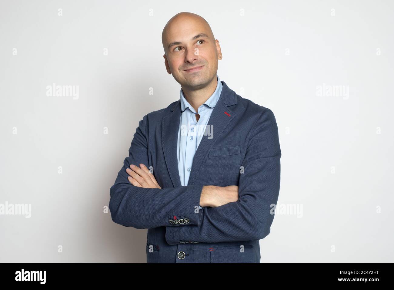 Bell'uomo baldastro di mezza età si affaccia su una parete grigia da studio. Scatto in studio Foto Stock
