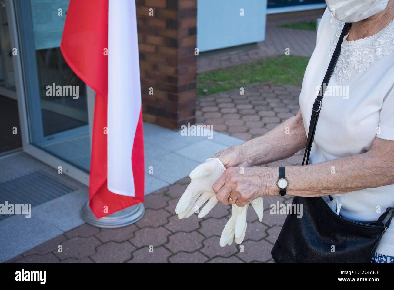 Poznan, Wielkopolska, Polonia. 28 Giugno 2020. Le elezioni presidenziali in Polonia sono iniziate alle 7. Nella foto: Una donna che è stata una delle prime votanti che si preparano a votare in un'elezione durante la pandemia - indossare guanti di lattice. Credit: Tatarkiewicz/ZUMA Wire/Alamy Live News Foto Stock