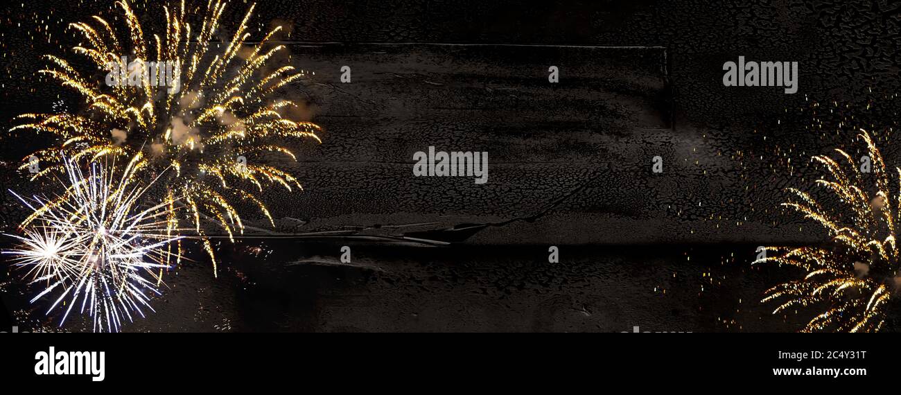 Fuochi d'artificio, fuochi d'artificio in silvestre bianco-oro su sfondo di legno nero-marrone e spazio per il testo Foto Stock