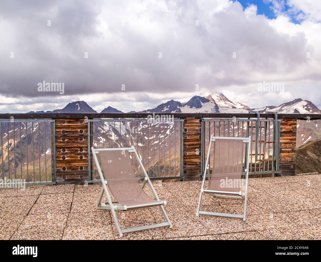Vista panoramica sulle montagne dalla terrazza panoramica con sedie a sdraio; Monte ghiacciaio Weisskugel (palla bianca) nelle alpi Ötztal, Schnalstal, Südtirol Foto Stock