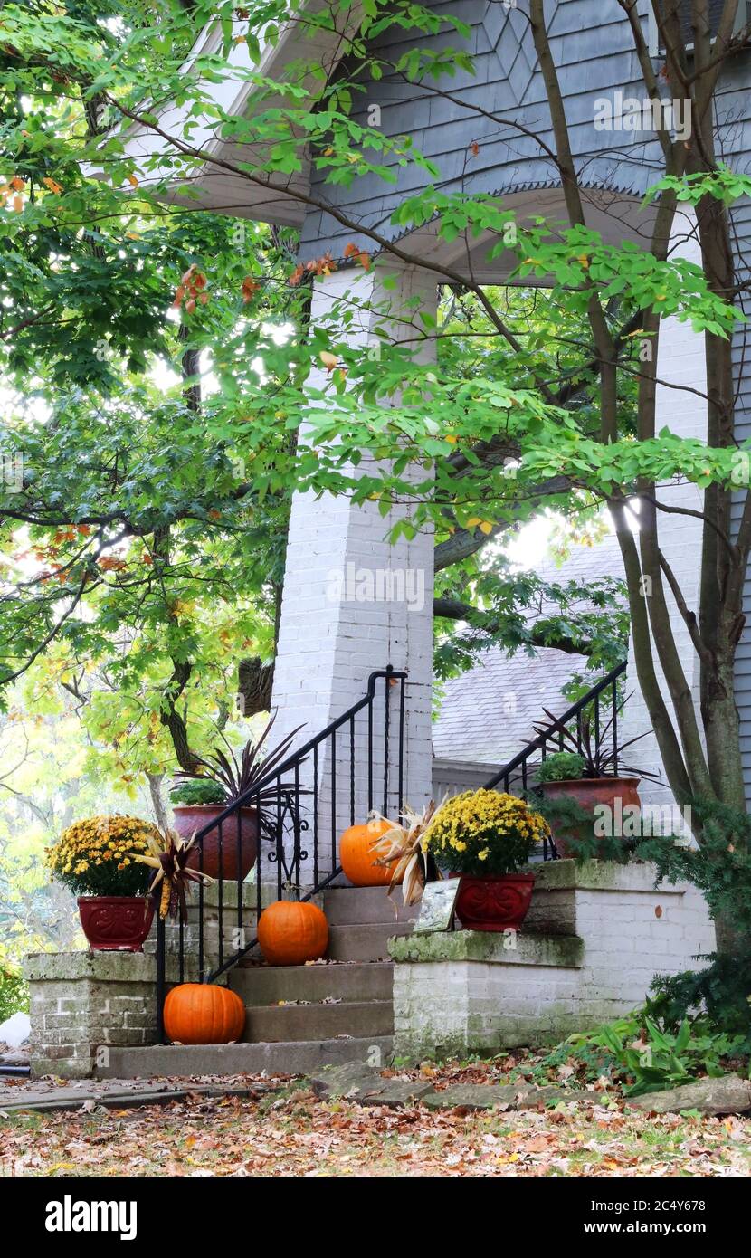 Scala di ingresso principale e portico della vecchia casa decorata per la stagione delle vacanze autunnali. Concetto di Halloween. Autunno sfondo. Composizione verticale. Foto Stock Scala di ingresso principale e portico della vecchia casa decorata per la stagione delle vacanze autunnali. Concetto di Halloween. Autunno sfondo. Composizione verticale. Foto Stock