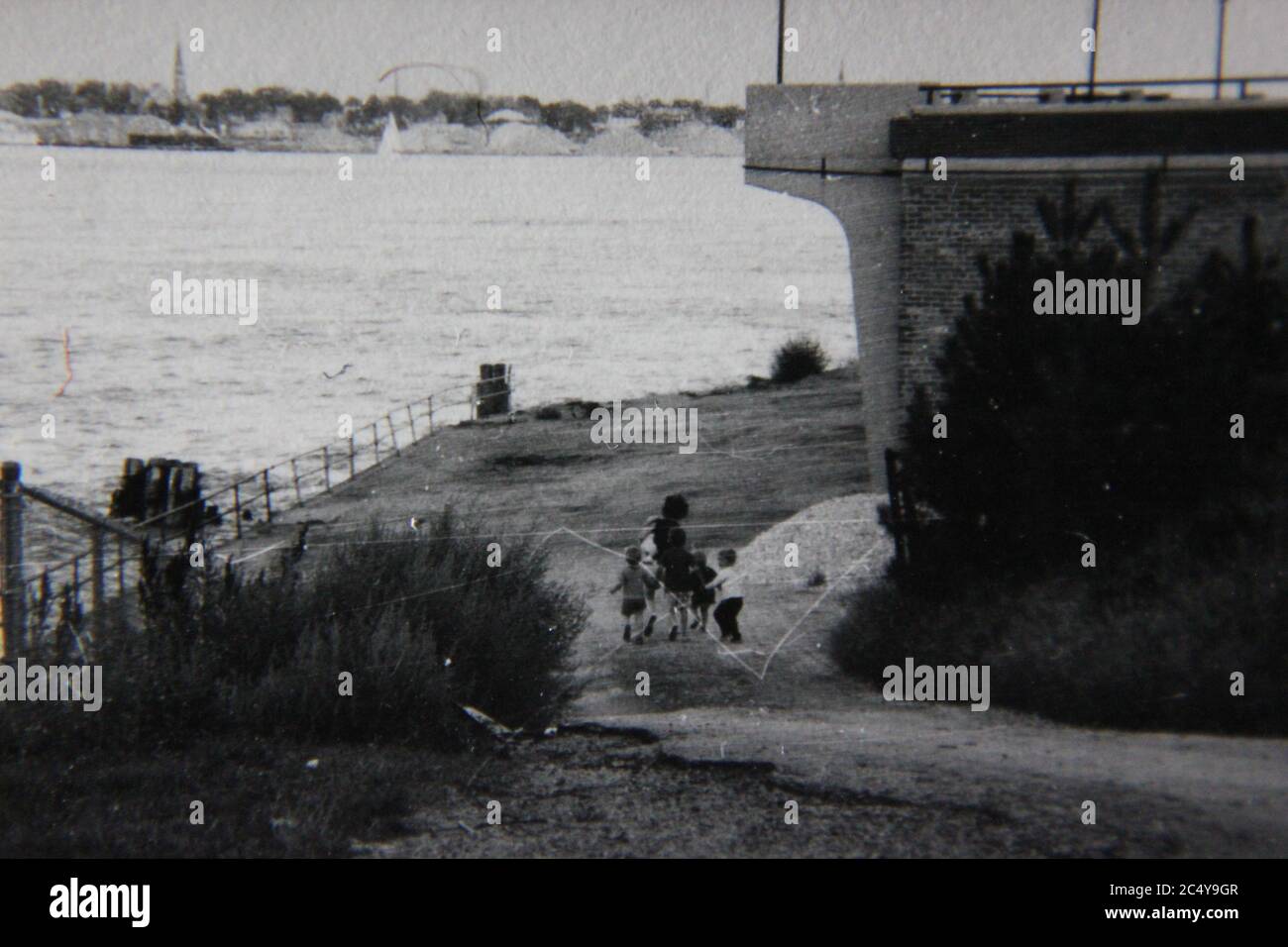 Bella fotografia in bianco e nero d'epoca degli anni '70 di un lungomare lungo le acque profonde. Foto Stock