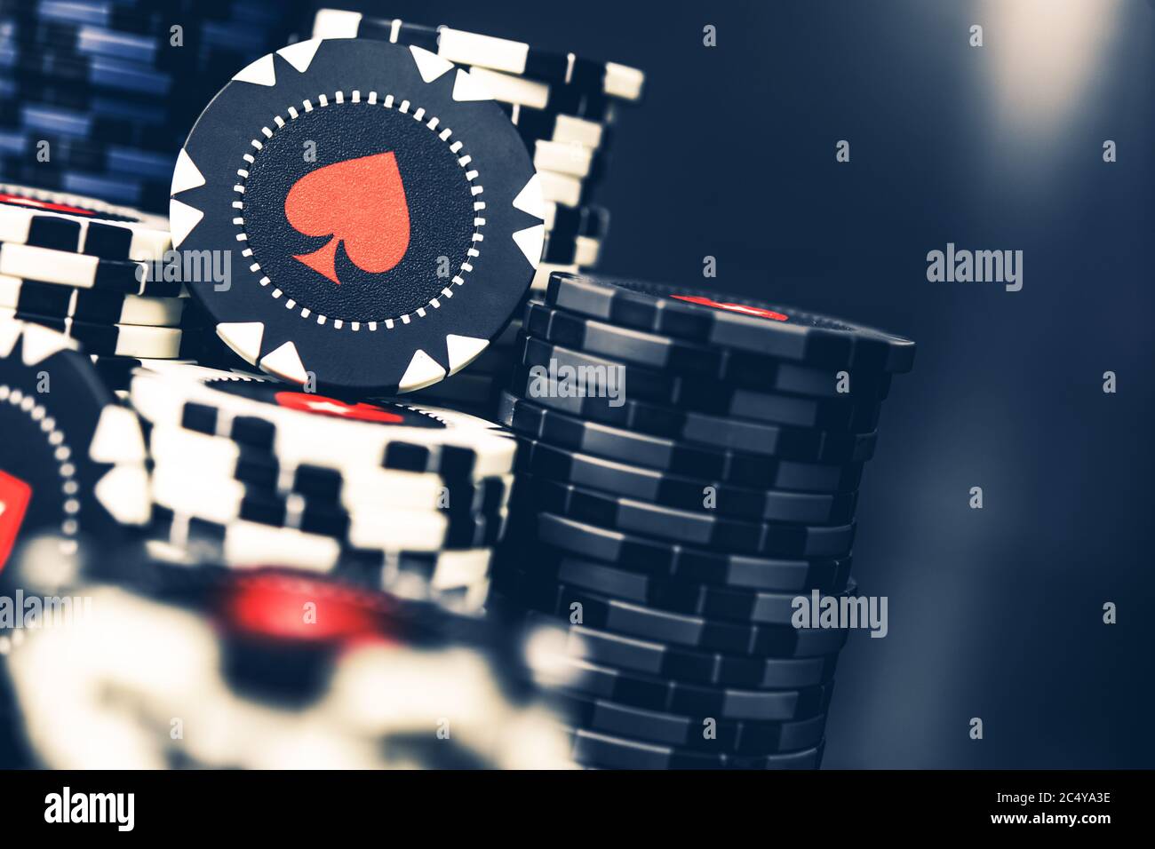 Tall pile di chip Poker Black e White Casino con simbolo della Spade Rossa. Foto Stock
