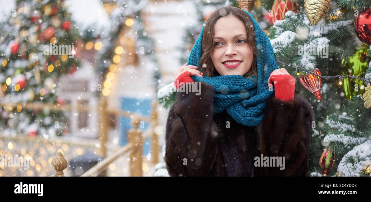 Bella donna in pelliccia cappotto sta camminando su una città invernale nei giorni di Capodanno Foto Stock