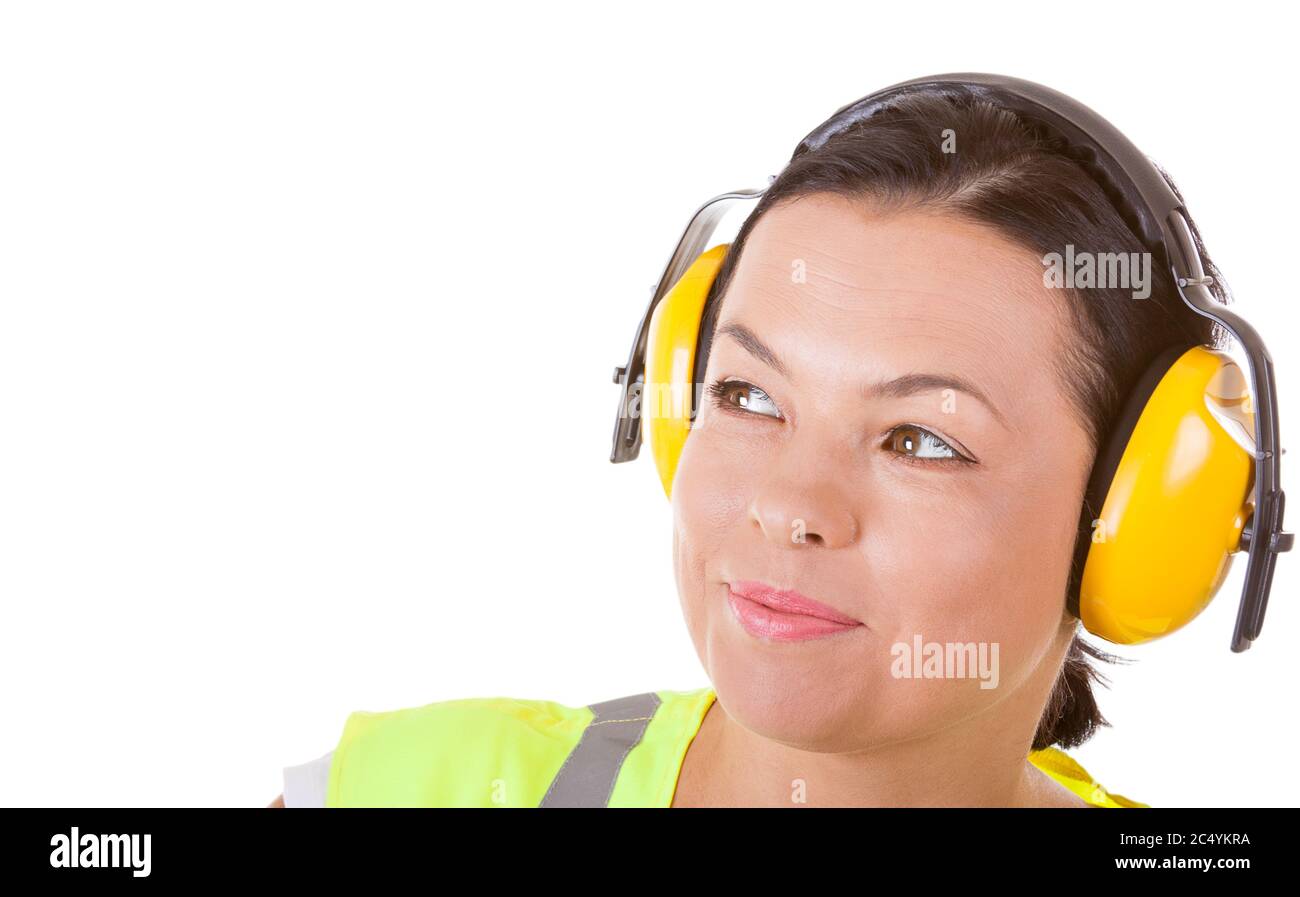 Attraente lavoratore donna in giacca di sicurezza e cuffie auricolari protettivi con CopySpace per il tuo design su sfondo bianco Foto Stock