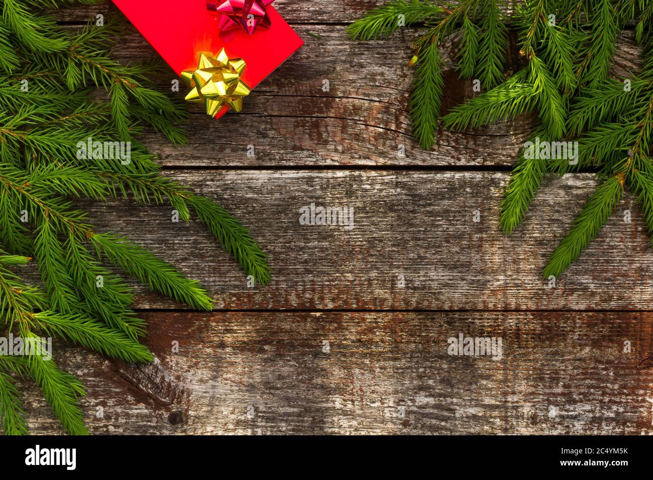 Sfondo di Natale per il biglietto d'auguri. Rami di abete su sfondo di legno. Foto Stock