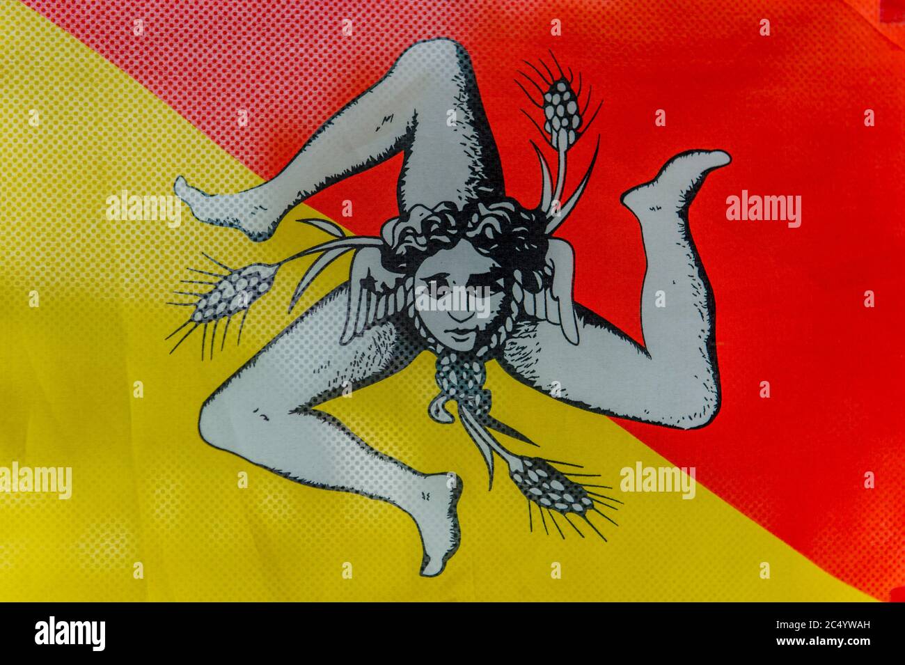 La bandiera siciliana con la Trinacria, antico simbolo che mostra la testa di Medusa circondata da tre gambe a corsa curvata, Italia. Foto Stock
