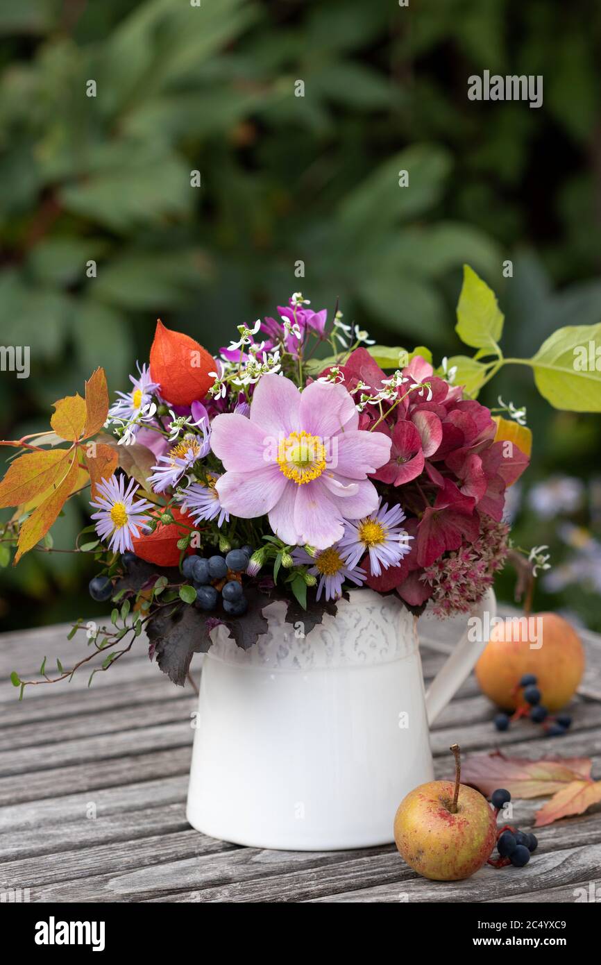 bouquet di fiori d'autunno in vaso sul tavolo da giardino Foto Stock