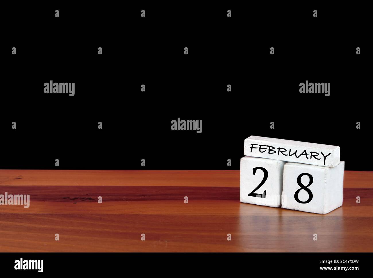 28 febbraio mese di calendario. 28 giorni del mese. Calendario riflesso su pavimento in legno con sfondo nero Foto Stock