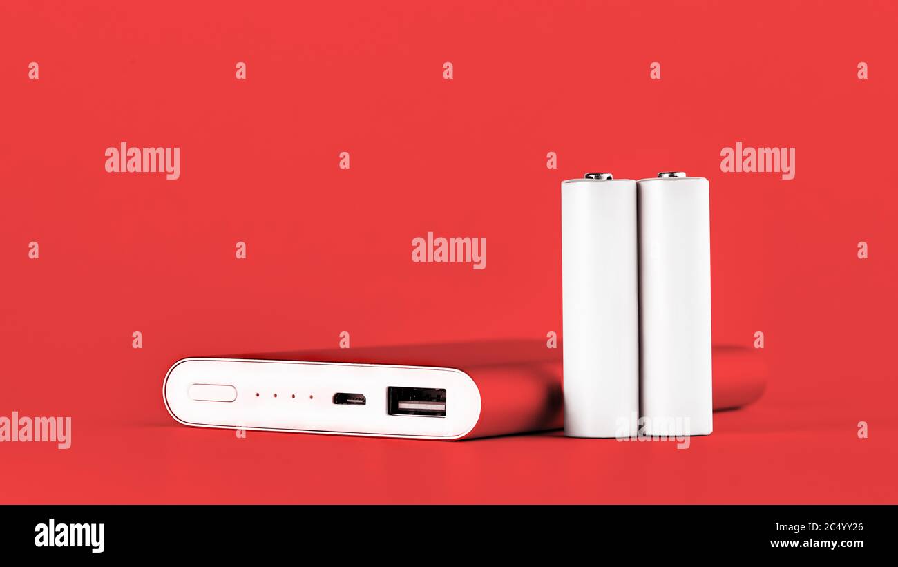 Power bank rosso portatile per la ricarica di dispositivi mobili e batterie AA. Ricarica mobile, alimentatori moderni. Foto Stock