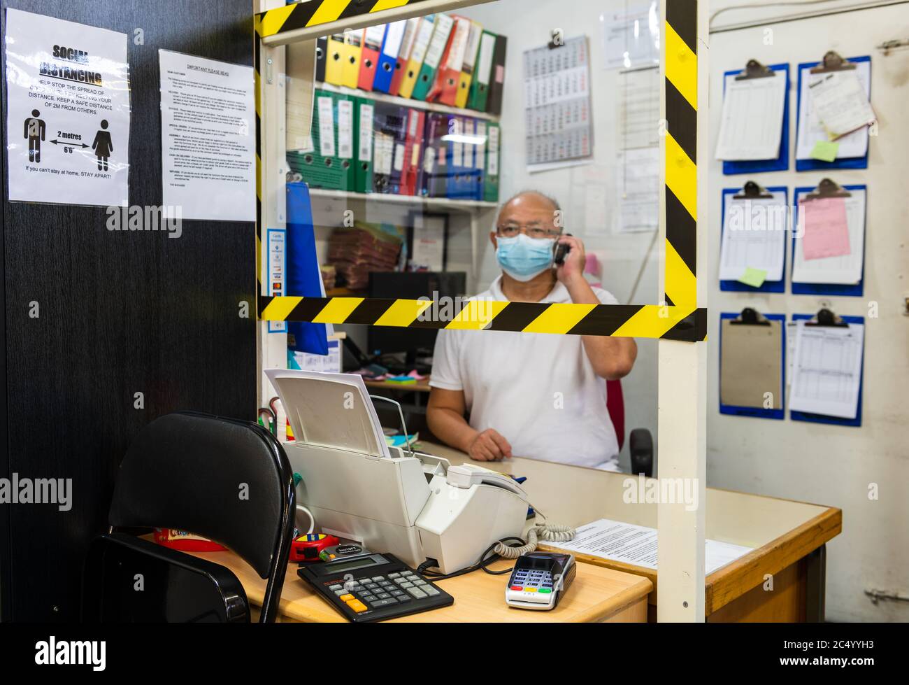 Divisori di schermo davanti a una scrivania in un rivenditore di mobili per conformarsi alle regole di distanziamento sociale del governo. Foto Stock