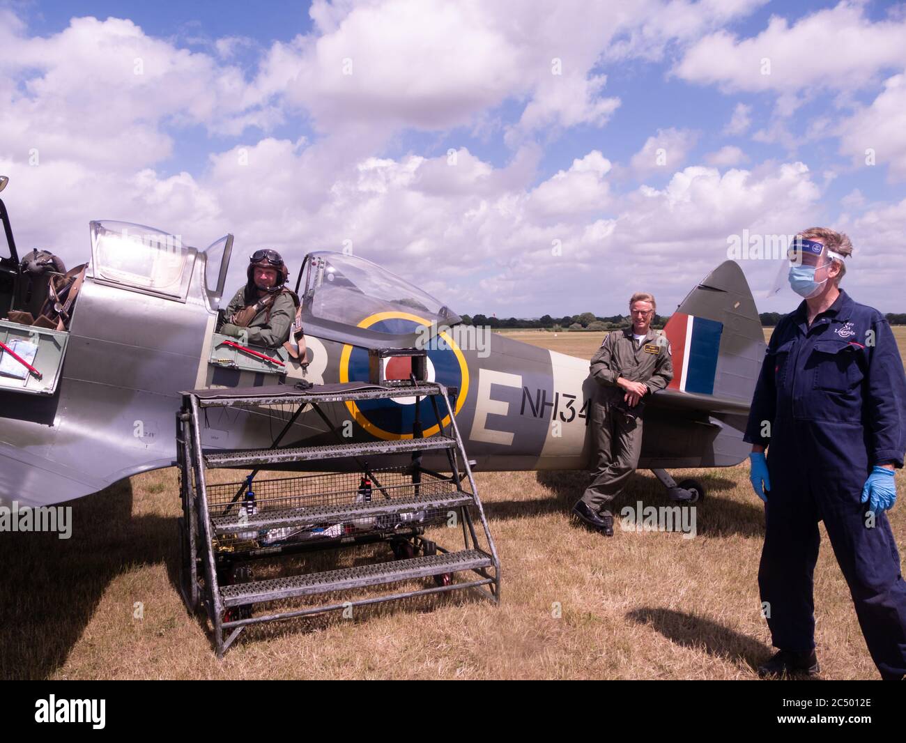 Un volo passeggeri in un Supermarine Spitfire IX ad Aero Legends, Headcorn (Lashenden), Kent, UK. L'equipaggio di terra indossa DPI per Coronavirus Covid-19 Foto Stock