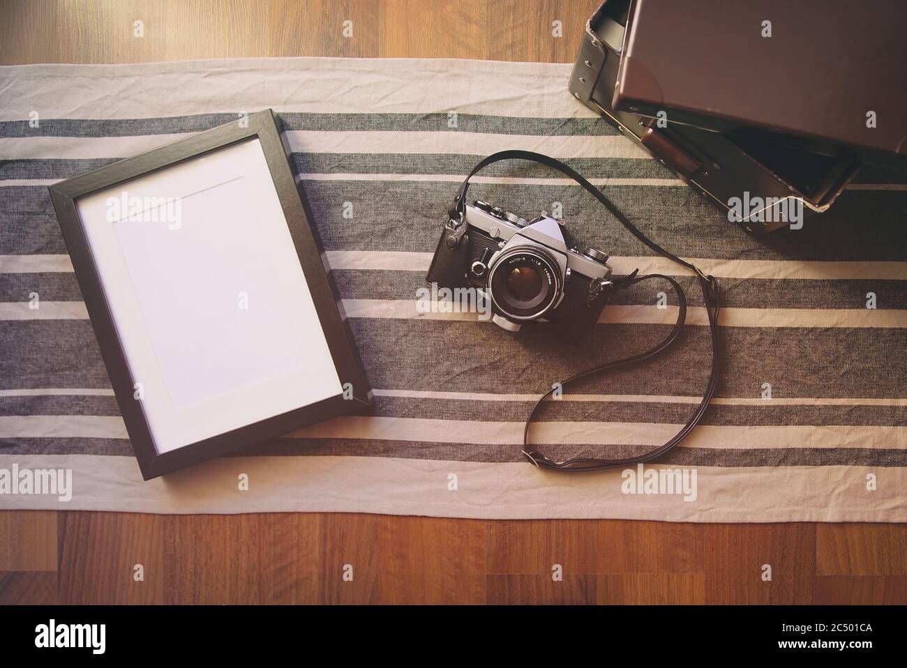 Fotocamera d'epoca e cornice fotografica vuota su tavolo di legno. Foto Stock