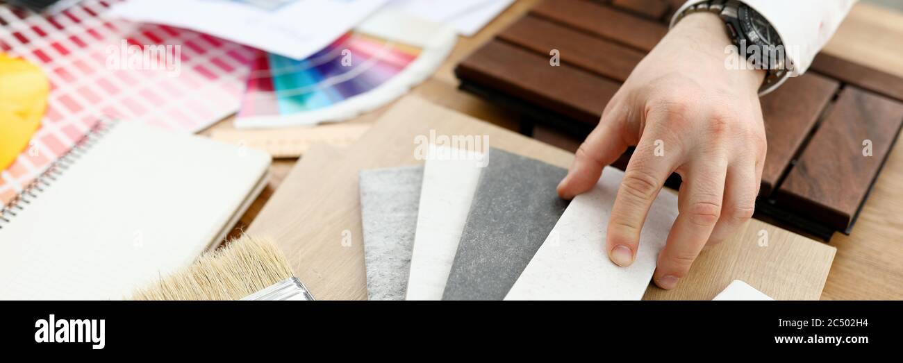 Maschio designer mano tenere penna argento contro il trend tavolozza colori Foto Stock