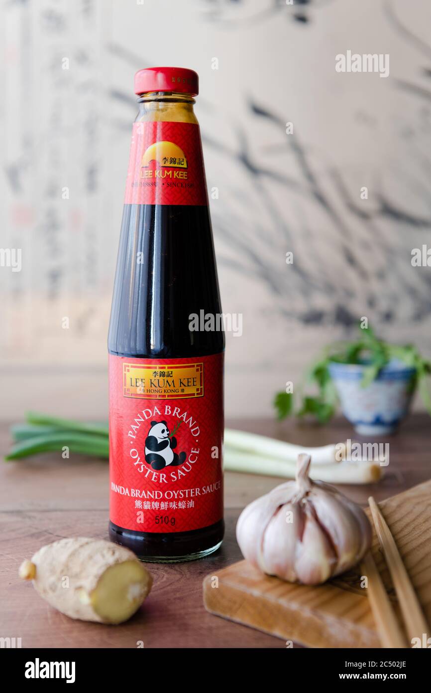 Una bottiglia di salsa di ostriche Panda Brand su un piano di lavoro  circondato da zenzero, aglio e cipolle Foto stock - Alamy