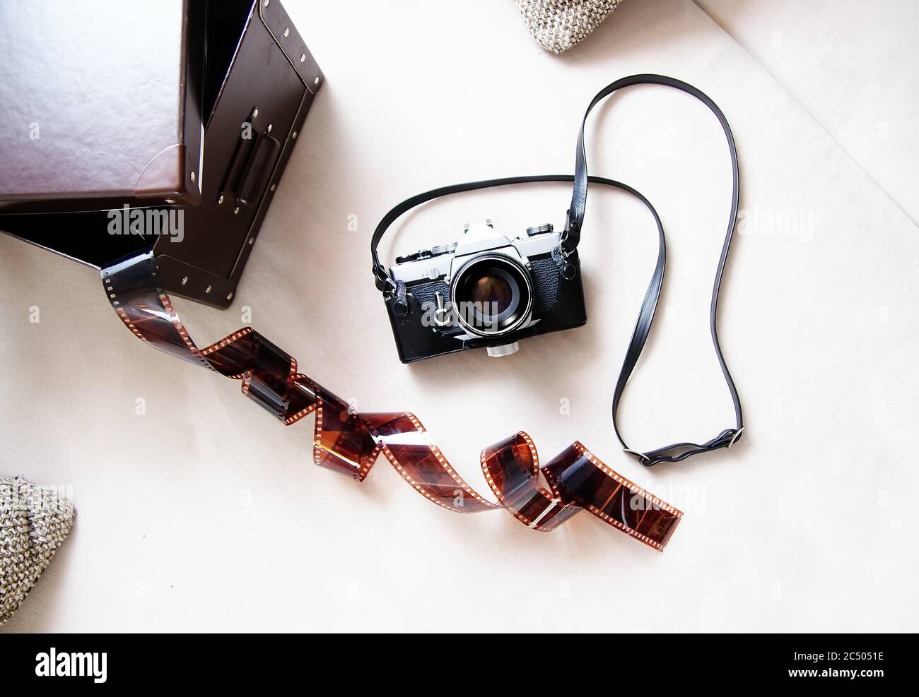 Fotocamera con telemetro vintage con custodia in pelle e pellicola fotografica su sfondo chiaro. Foto Stock