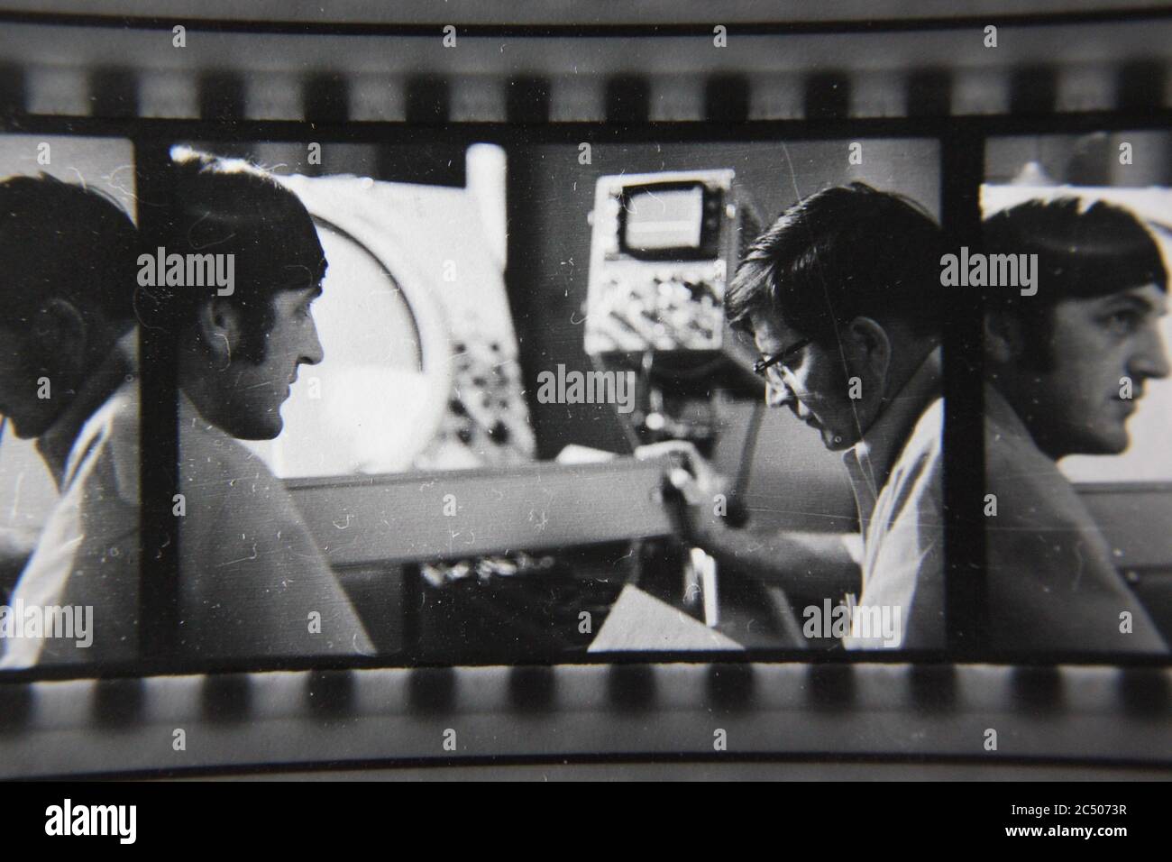 Fine anni '70 vintage contatto stampa in bianco e nero fotografia di due professionisti che hanno una discussione tecnica di fronte a uno schermo radar. Foto Stock