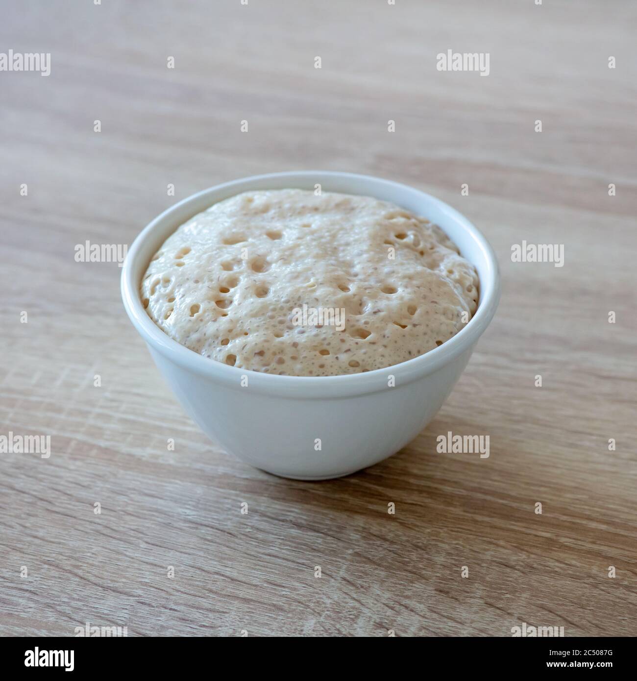 lievito in una ciotola su tavolo da cucina in legno Foto Stock