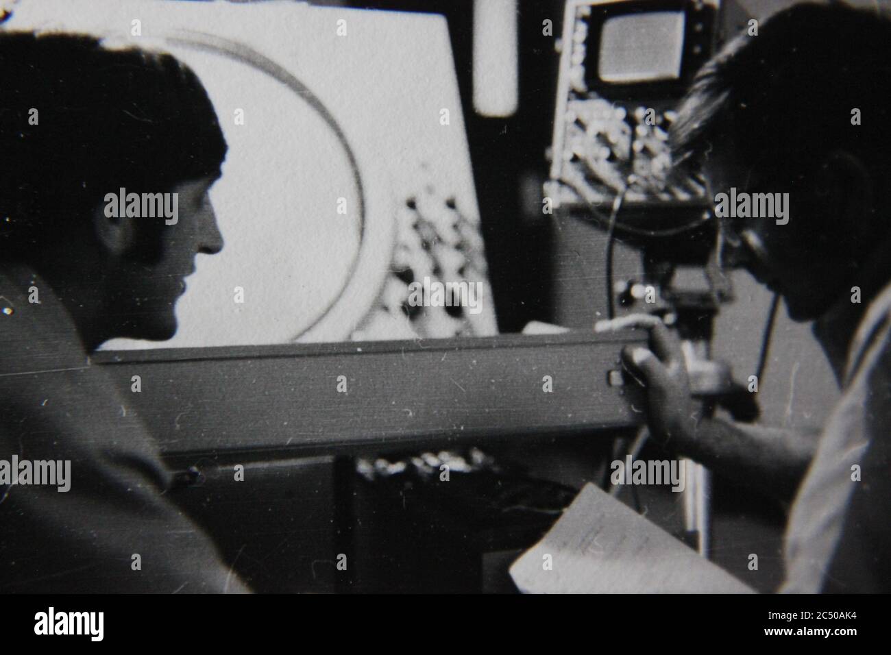 Bella fotografia in bianco e nero anni '70 di due professionisti che hanno una discussione di fronte allo schermo radar. Foto Stock