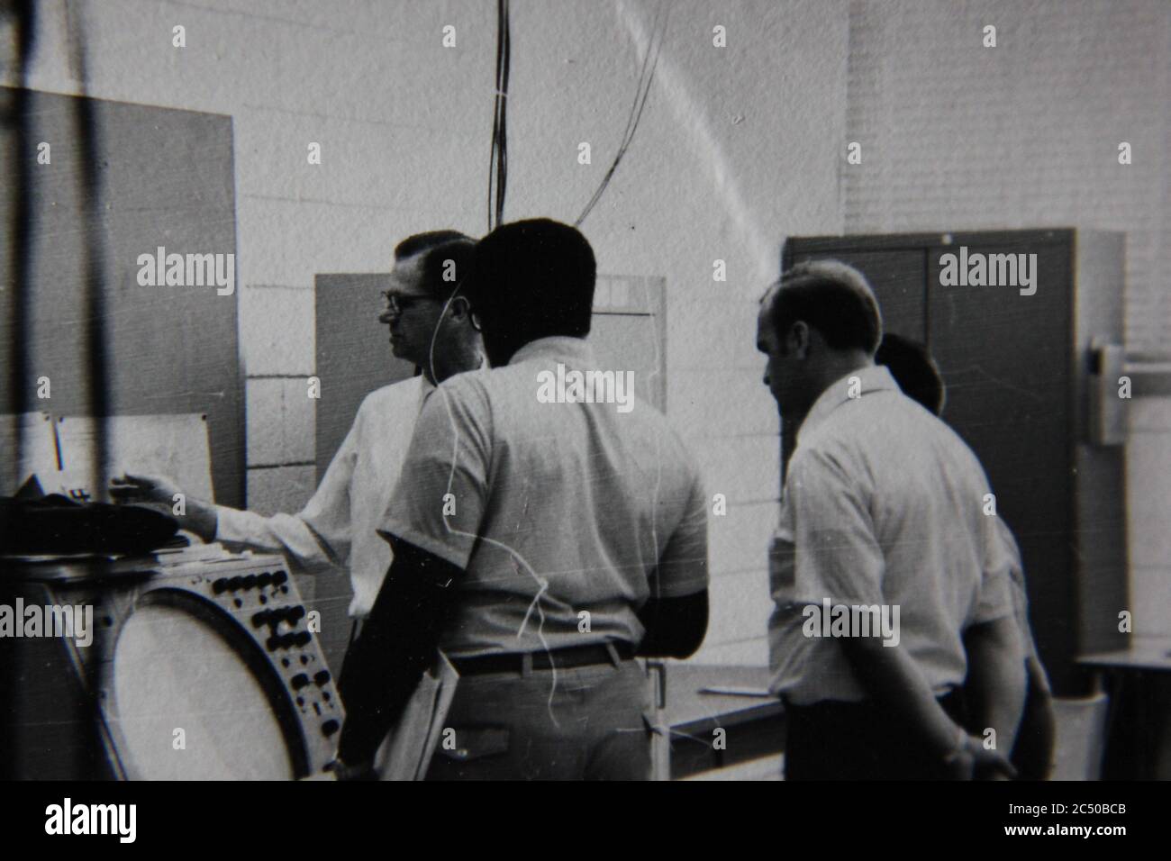 Bella fotografia in bianco e nero degli anni '70 di tre professionisti che tengono una riunione di strategia. Foto Stock