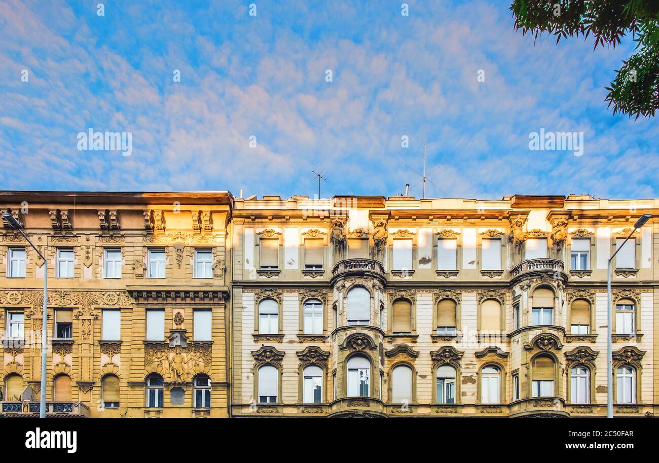 Budapest, Ungheria, 2019 agosto, vista della parte superiore di due edifici con sculture architettoniche al tramonto Foto Stock