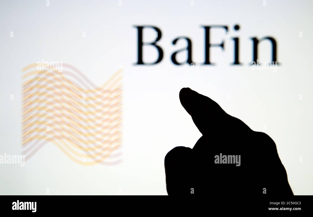 Logo BaFin (Federal Financial Supervisory Authority) sullo schermo sfocato e sulla sagoma del dito che punta Foto Stock