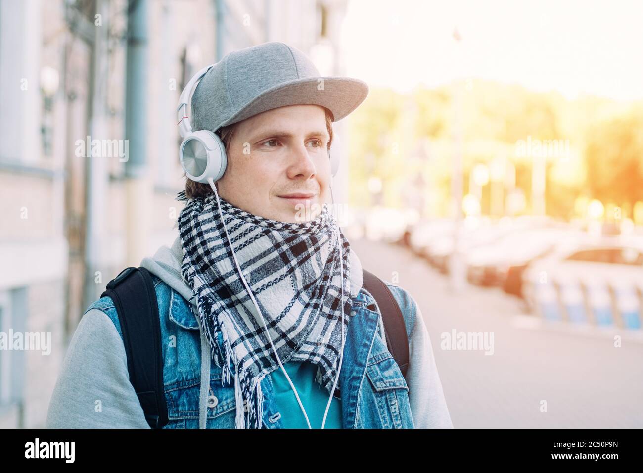 L'uomo caucasico con cappuccio grigio ascolta la musica sulle cuffie. Foto Stock