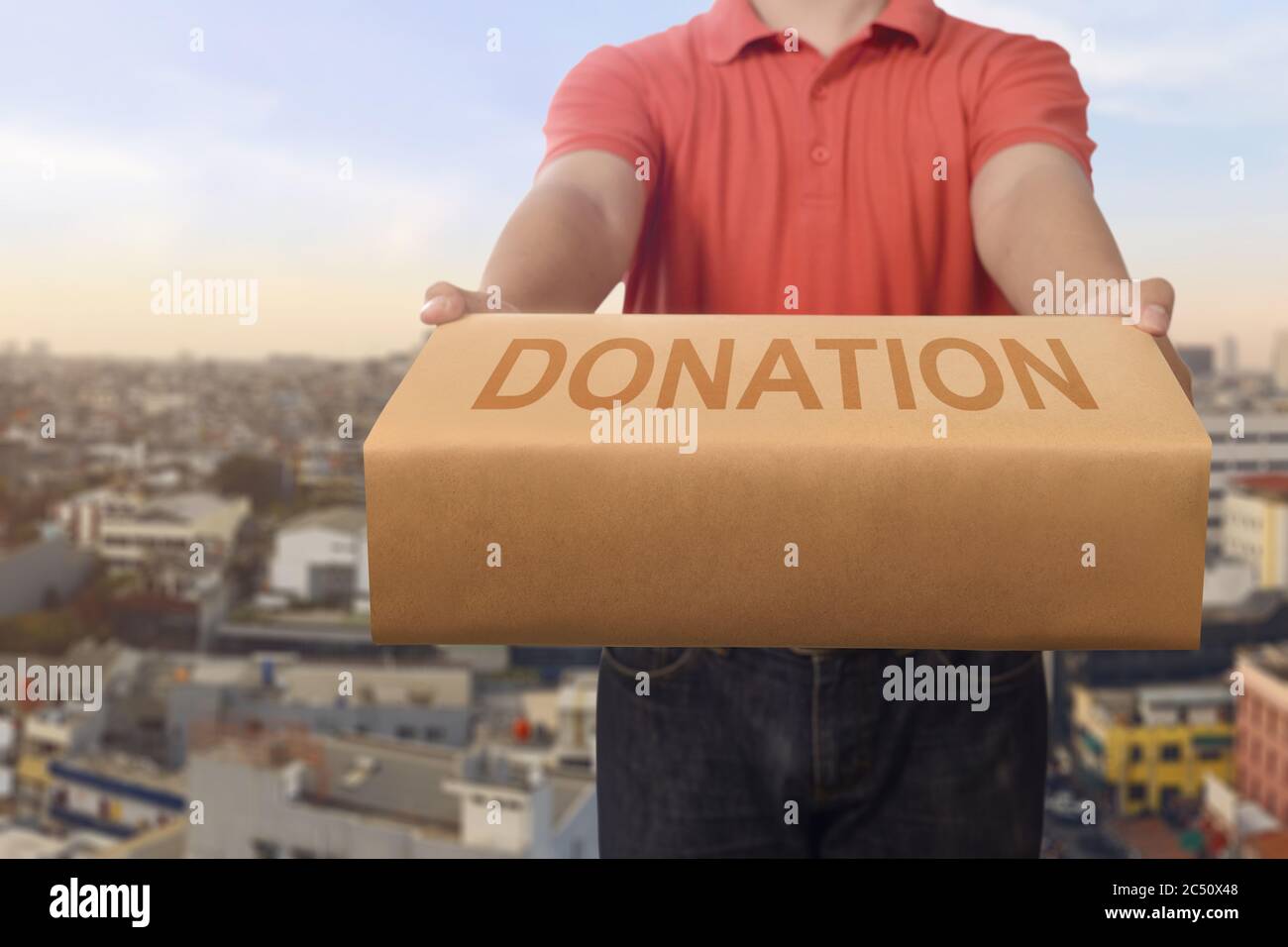 Uomo che dà scatola di donazione per carità nella città Foto Stock