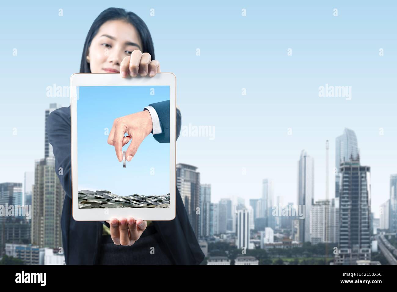 Donna d'affari asiatica che tiene tablet con dare messaggio di donazione sullo schermo della città Foto Stock