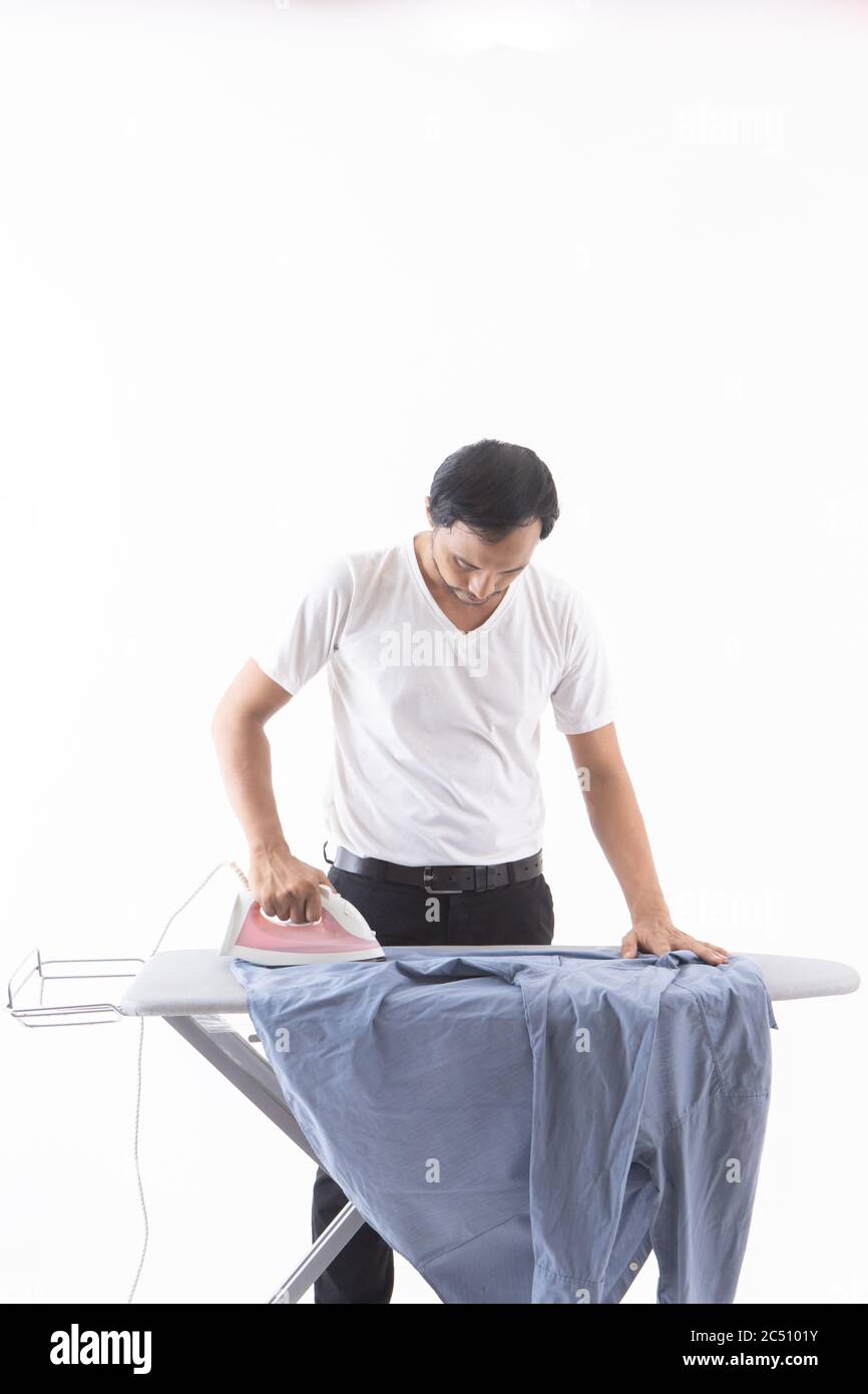 Gli uomini asiatici lavorano a stirare su sfondo bianco. Camicia blu rugosa Foto Stock