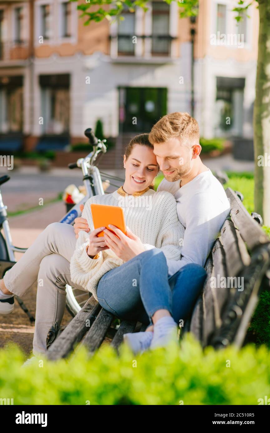 Giovane uomo e donna riposati su panca con l'atablet Foto Stock