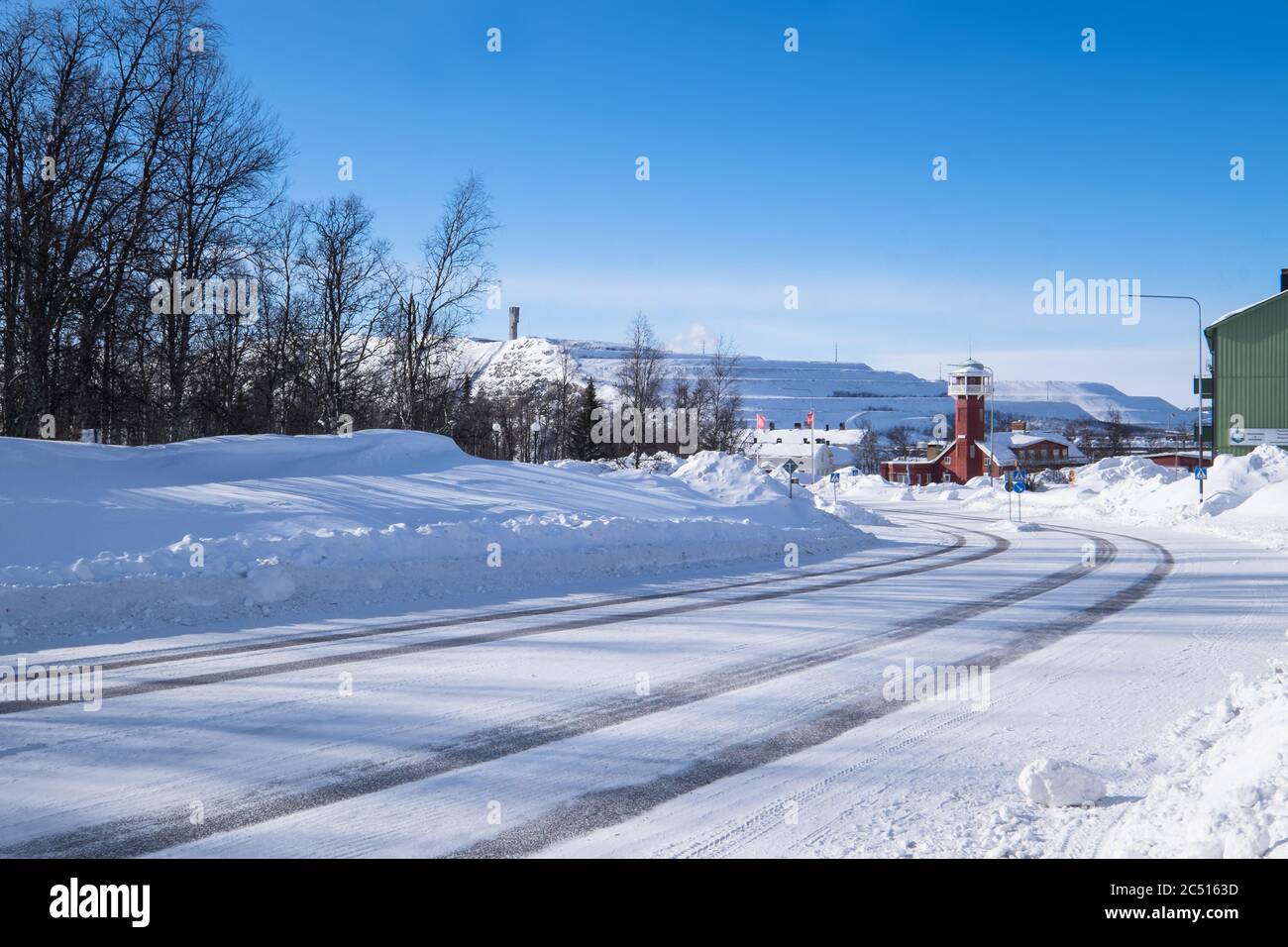 Vecchia firestation di Kiruna in inverno, ora usato come stazione TV regionale. In background, le fabbriche della LKAB, una grande società svedese di estrazione del ferro Foto Stock