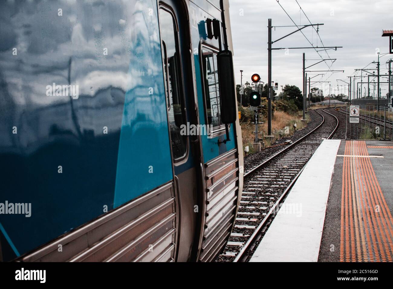 Un treno elettrico a Melbourne Australia, seduto ad un segnale presso una piattaforma di stazione Foto Stock