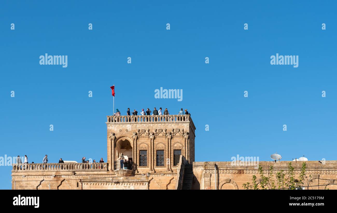 Midyat, Mardin, Turchia - Ottobre 2019: Turisti in visita Midyat state Guest House, famosa per l'architettura tradizionale. Adatto per spazio di copia Foto Stock