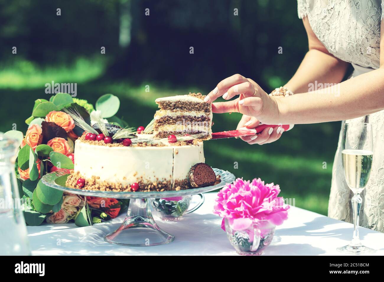 sposa taglio fetta di torta nuziale Foto Stock