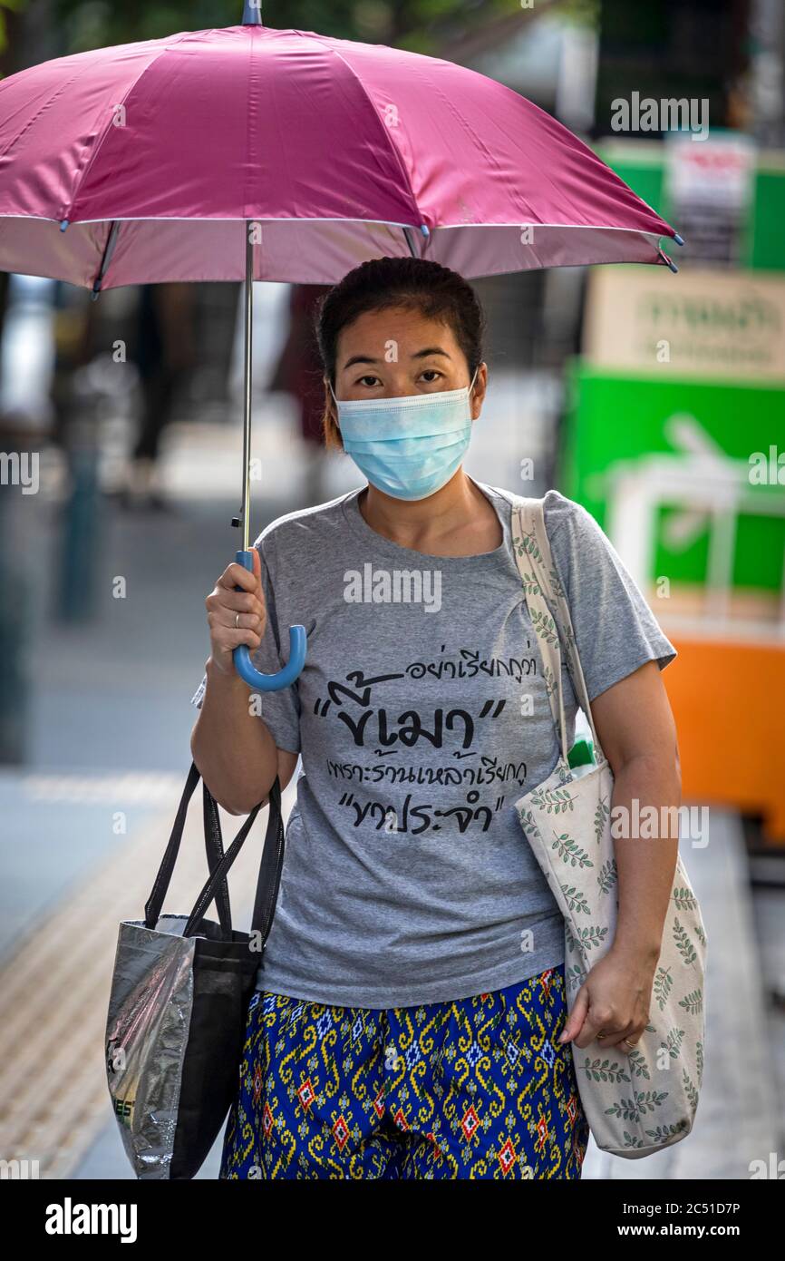 Ragazza con maschera e ombrello durante la covid 19 pandemia, Bangkok, Thailandia Foto Stock