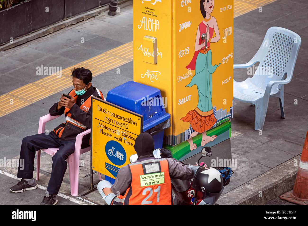 Motociclisti in taxi con maschera facciale e telefono cellulare durante la pandemia covid 19, Bangkok, Thailandia Foto Stock