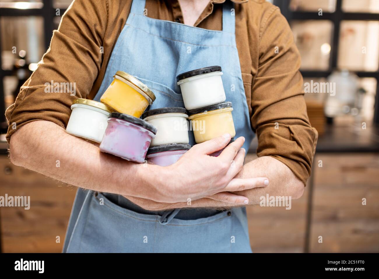 I venditori tengono vasi con gusti di gelato variorus al negozio Foto Stock